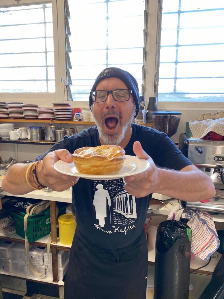 A cafe team member holding a pie